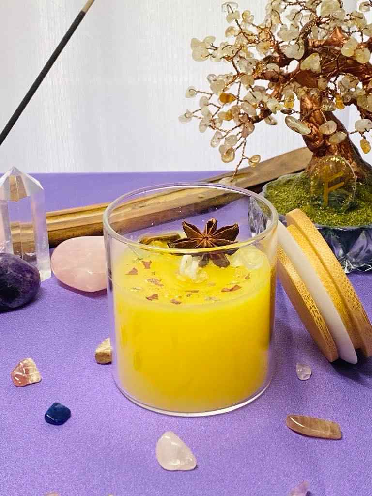 Vela de la abundancia encendida sobre un altar con elementos naturales, usada en rituales para atraer prosperidad y bienestar.
